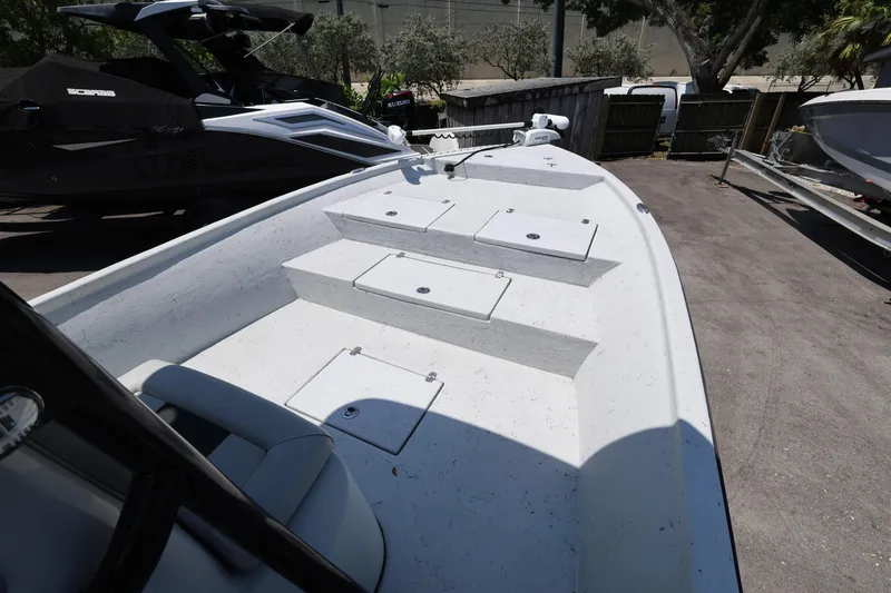 Slide: The Image of 2021 Blazer Bay 2400 boat deck with storage compartments, parked outdoors. - 19