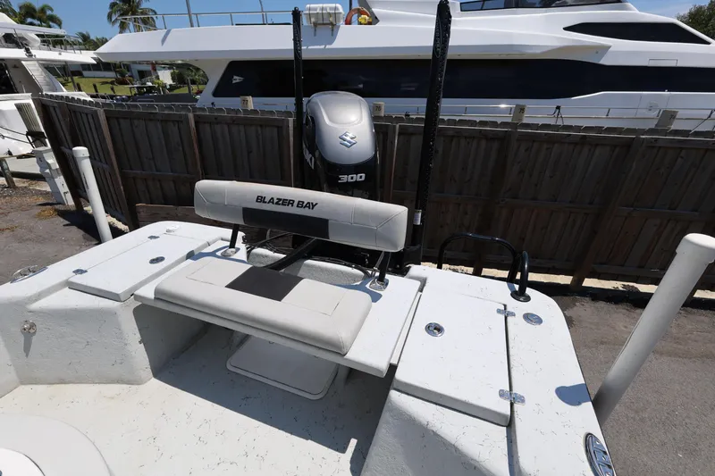 Slide: The Image of 2021 Blazer Bay 2400 boat with Suzuki 300 engine, docked near a yacht. - 28