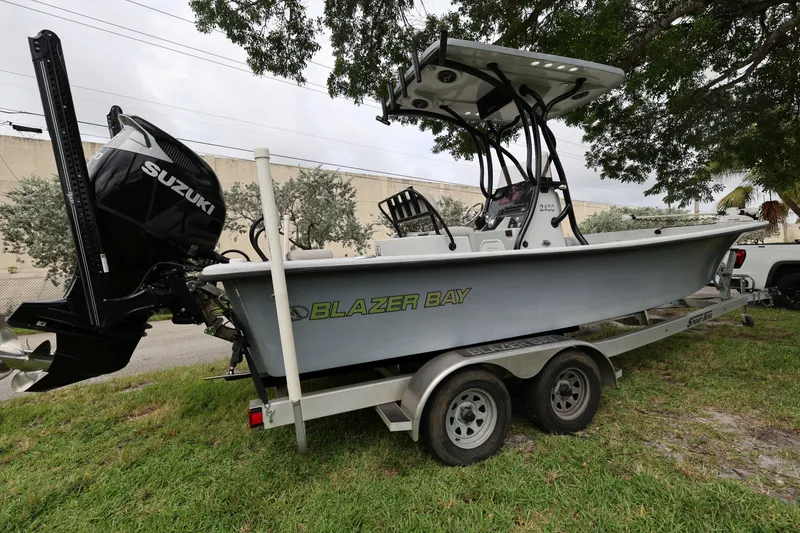 Slide: The Image of 2021 Blazer Bay 2400 boat with Suzuki engine on a trailer, parked on grass. - 6