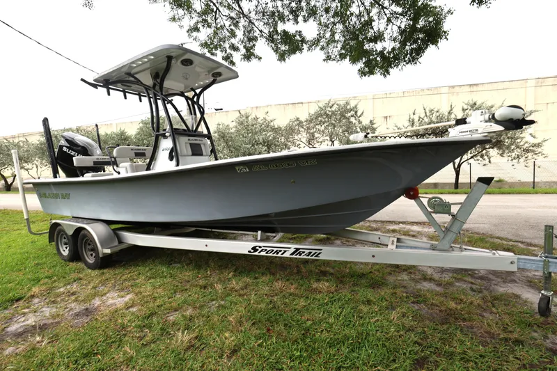 Slide: The Image of 2021 Blazer Bay 2400 boat on trailer, parked on grass, side view. - 9