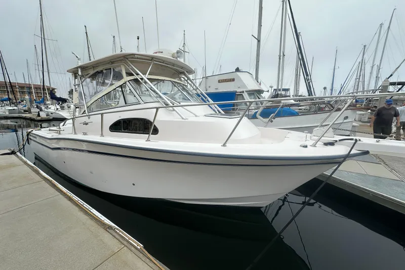 Slide: The Image of 2001 Grady-White Marlin 300 boat docked at a marina, surrounded by sailboats. - 0