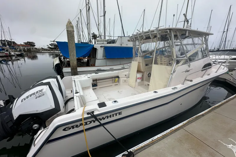 Slide: The Image of 2001 Grady-White Marlin 300 boat docked, featuring Evinrude engine, in a marina setting. - 1