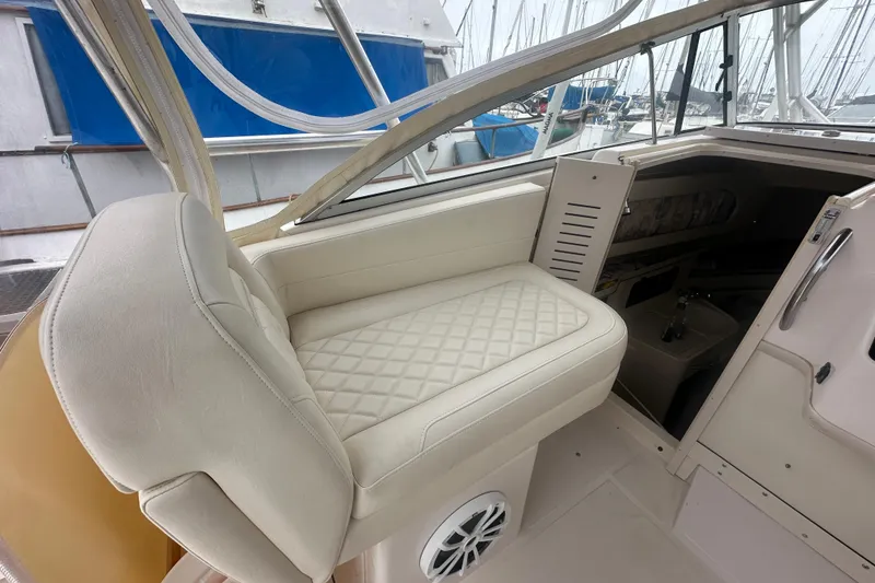 Slide: The Image of 2001 Grady-White Marlin 300 boat interior with cushioned seating and cabin view. - 16