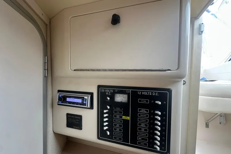 Slide: The Image of Electrical panel inside a 2001 Grady-White Marlin 300 boat, featuring AC and DC controls. - 18