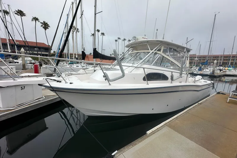 Slide: The Image of 2001 Grady-White Marlin 300 boat docked in a marina with palm trees. - 2