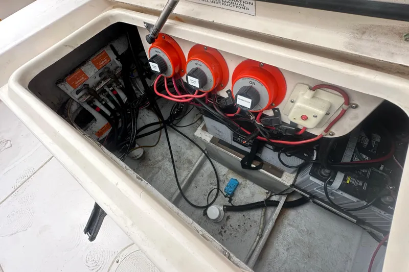 Slide: The Image of Electrical compartment of a 2001 Grady-White Marlin 300 boat, showing wiring and battery switches. - 21