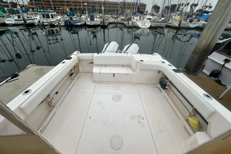 Slide: The Image of 2001 Grady-White Marlin 300 boat interior at marina, showcasing spacious seating and clean deck. - 25
