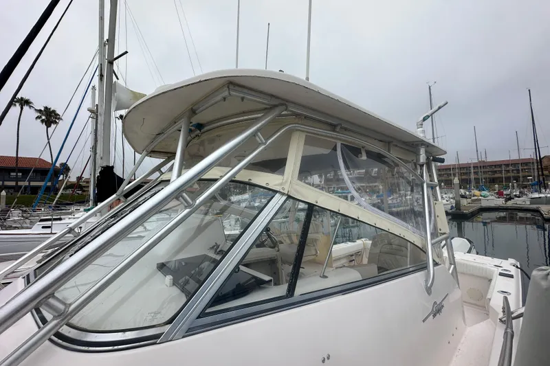 Slide: The Image of 2001 Grady-White Marlin 300 boat docked in a marina, showcasing its cabin and structure. - 3