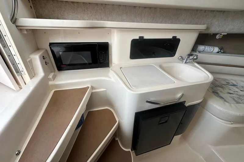 Slide: The Image of Compact kitchen area in a 2001 Grady-White Marlin 300 boat with microwave and sink. - 5