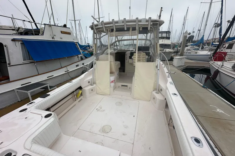 Slide: The Image of 2001 Grady-White Marlin 300 boat docked at marina, featuring spacious deck and seating. - 9