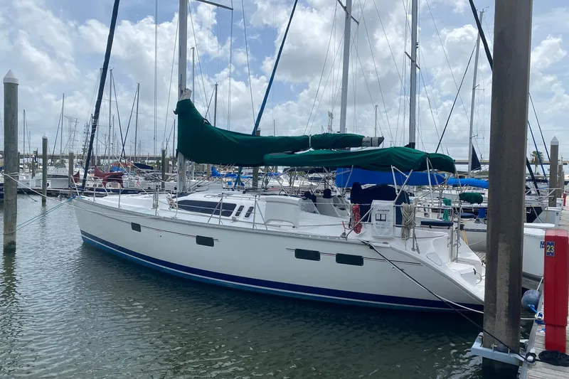 Slide: The Image of 1996 Hunter Legend 40.5 sailboat docked in marina, featuring green sail covers. - 32