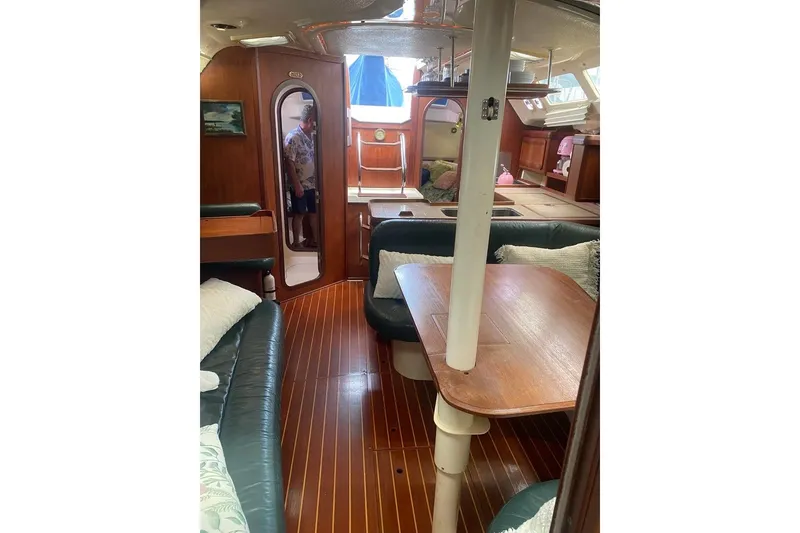 Slide: The Image of Interior of 1996 Hunter Legend 40.5 sailboat with wooden furnishings and cozy seating. - 8