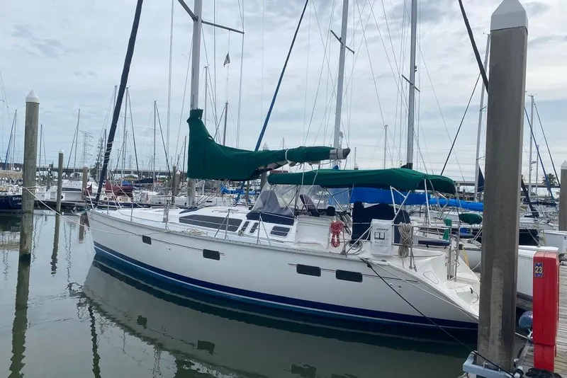 Slide: The Image of 1996 Hunter Legend 40.5 sailboat docked at marina, featuring green sail covers. - 5