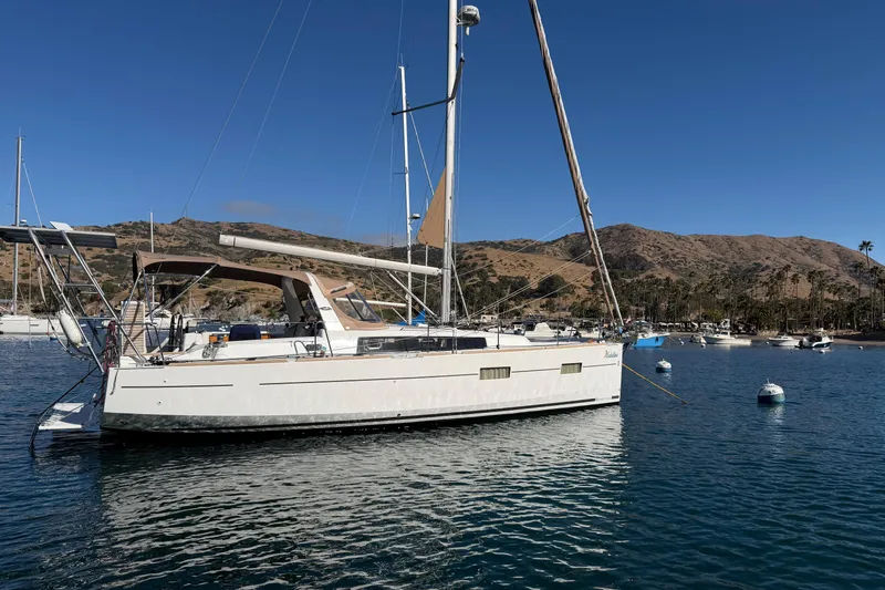Slide: The Image of 2017 Beneteau Oceanis 38 sailboat anchored in scenic coastal waters. - 1