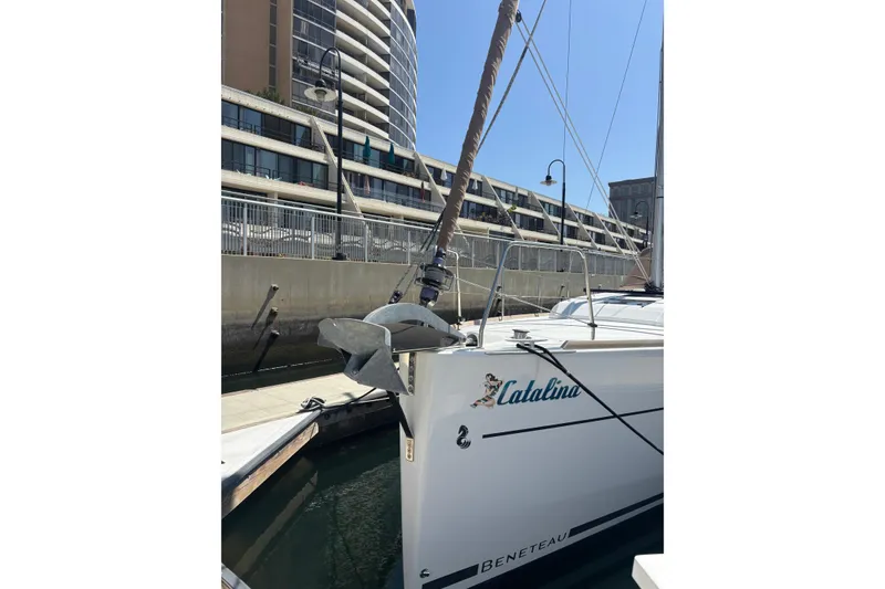 Slide: The Image of 2017 Beneteau Oceanis 38 sailboat docked in marina, urban buildings in background. - 10