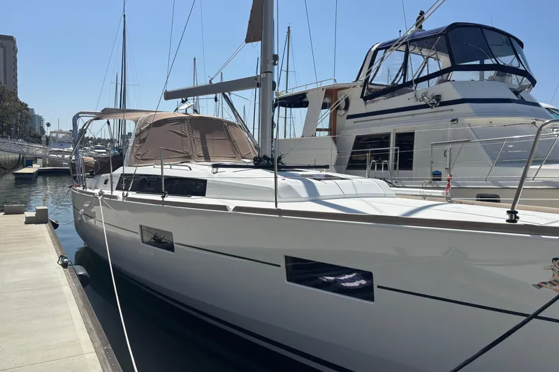 Slide: The Image of 2017 Beneteau Oceanis 38 sailboat docked at a marina under clear skies. - 12