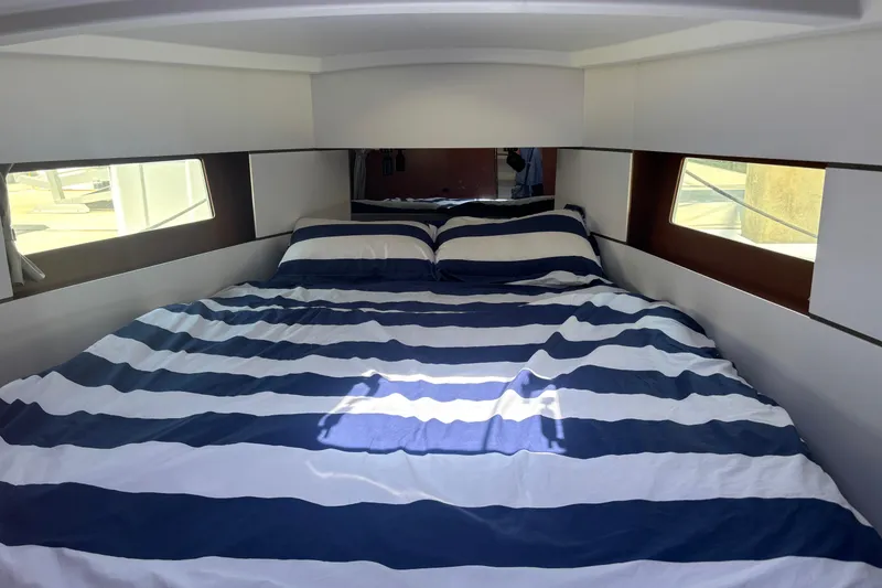 Slide: The Image of Cozy cabin interior of 2017 Beneteau Oceanis 38 with striped bedding and side windows. - 29
