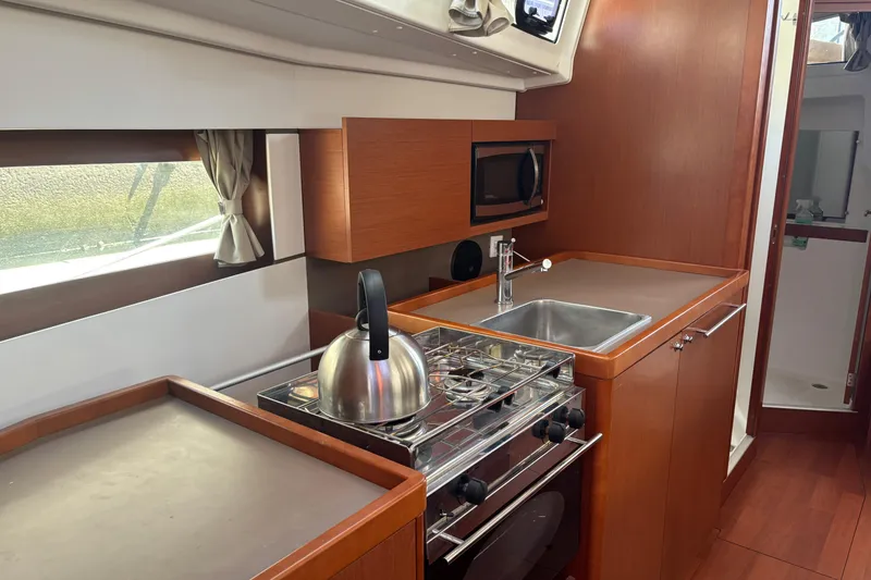Slide: The Image of Modern kitchen interior of 2017 Beneteau Oceanis 38 yacht with stove, sink, and microwave. - 30