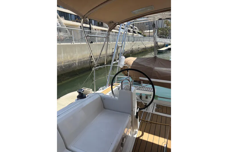 Slide: The Image of 2017 Beneteau Oceanis 38 sailboat cockpit with steering wheel, docked at marina. - 37
