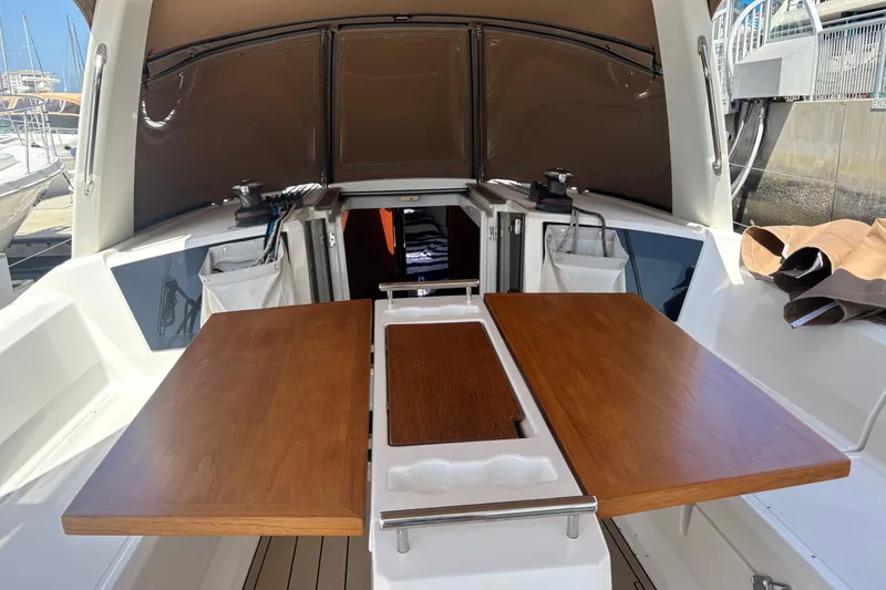 Slide: The Image of Cockpit of 2017 Beneteau Oceanis 38 sailboat with wooden table and open hatch. - 38