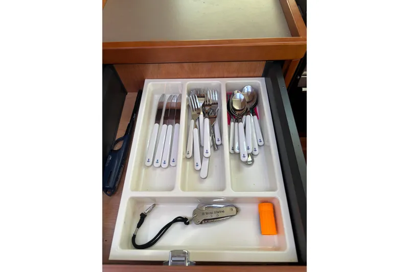 Slide: The Image of Cutlery drawer on 2017 Beneteau Oceanis 38 yacht, featuring organized utensils and tools. - 46
