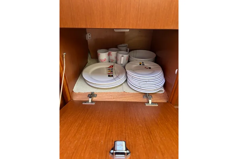 Slide: The Image of Cabinet with neatly stacked plates and cups on a 2017 Beneteau Oceanis 38 yacht. - 48