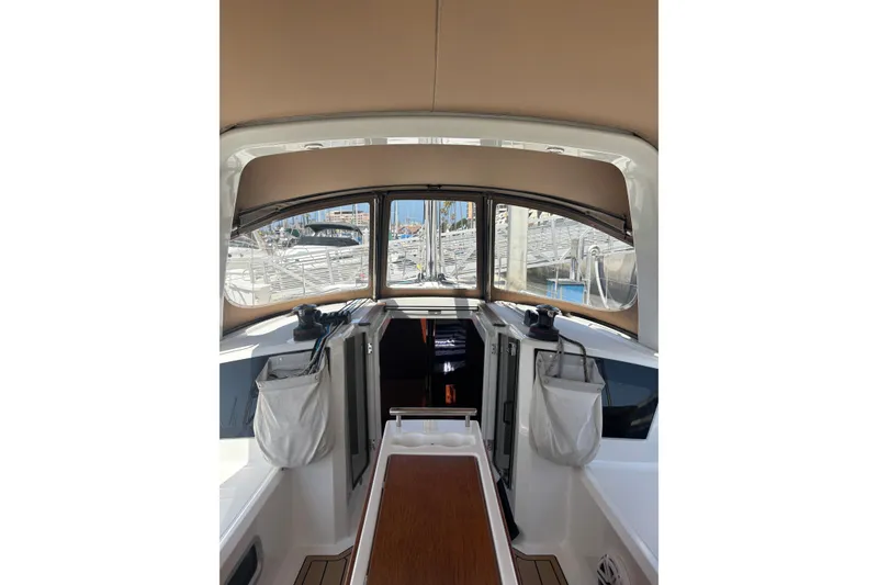Slide: The Image of 2017 Beneteau Oceanis 38 cockpit view with marina background, showcasing modern design. - 49