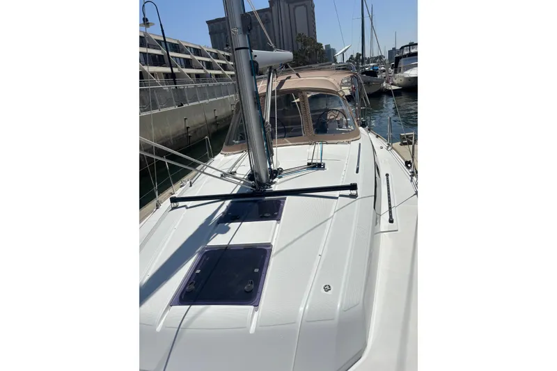 Slide: The Image of 2017 Beneteau Oceanis 38 sailboat docked at marina, showcasing sleek deck design. - 53
