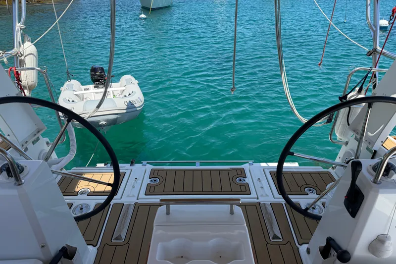 Slide: The Image of Cockpit view of 2017 Beneteau Oceanis 38 sailboat with dinghy on turquoise water. - 6