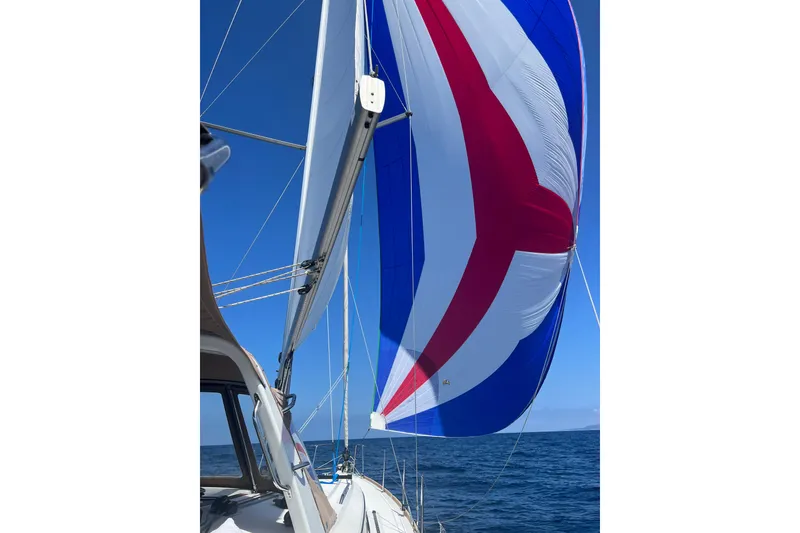 Slide: The Image of 2017 Beneteau Oceanis 38 sailing with colorful spinnaker against clear blue sky. - 64