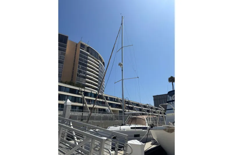 Slide: The Image of 2017 Beneteau Oceanis 38 sailboat docked near modern buildings under clear blue sky. - 8