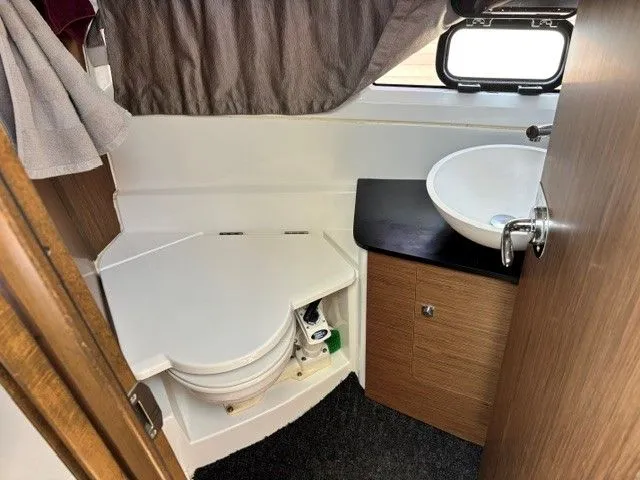 Slide: The Image of The image shows a boat bathroom with a toilet, sink, and small window. - 18