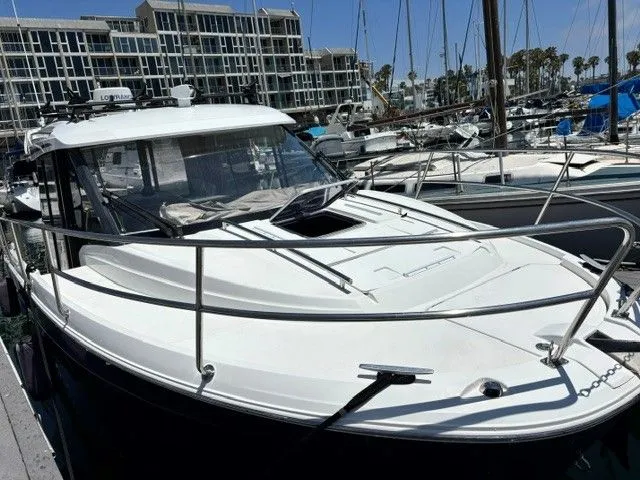 Slide: The Image of A 2019 Jeanneau NC 895 Offshore docked at a marina. It features a sleek design and spacious cabin. - 15