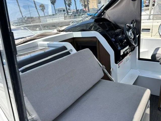 Slide: The Image of The image shows the cockpit of a 2019 Jeanneau NC 895 Offshore with gray upholstery. - 29