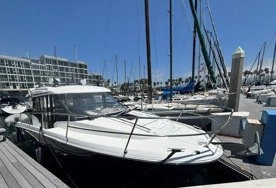 Slide: The Image of A 2019 Jeanneau NC 895 Offshore docked at a marina, surrounded by other boats. - 17