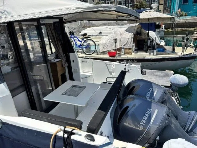 Slide: The Image of The image shows a 2019 Jeanneau NC 895 Offshore boat in a marina. It has two Yamaha engines. - 14