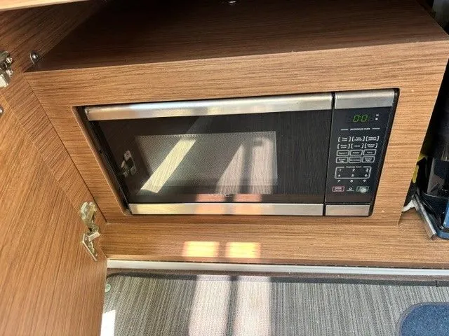 Slide: The Image of A microwave oven is built into a wooden cabinet, featuring a digital control panel. - 21