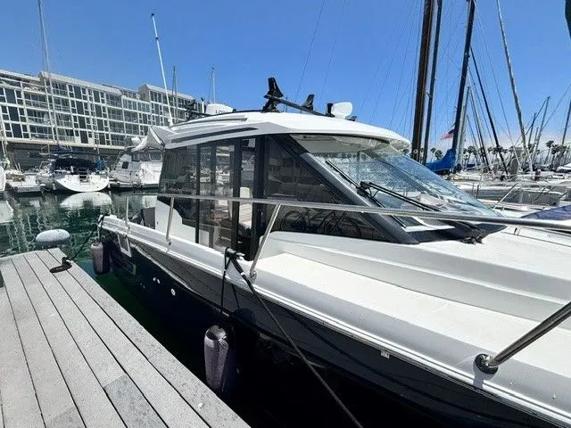 Slide: The Image of A 2019 Jeanneau NC 895 Offshore docked at a marina, surrounded by other boats. - 35