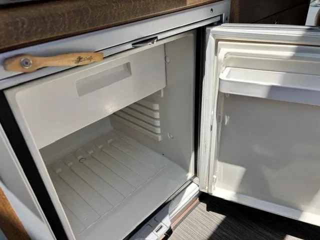 Slide: The Image of An open refrigerator inside a boat with wood paneling. - 23
