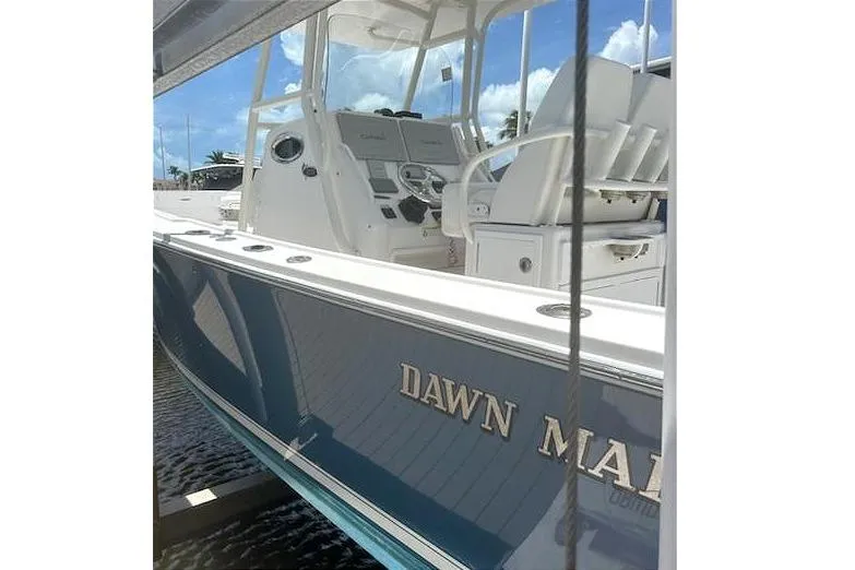 Slide: The Image of 2016 Regulator 28 Forward Seating boat with "Dawn Marie" name, docked under clear skies. - 1