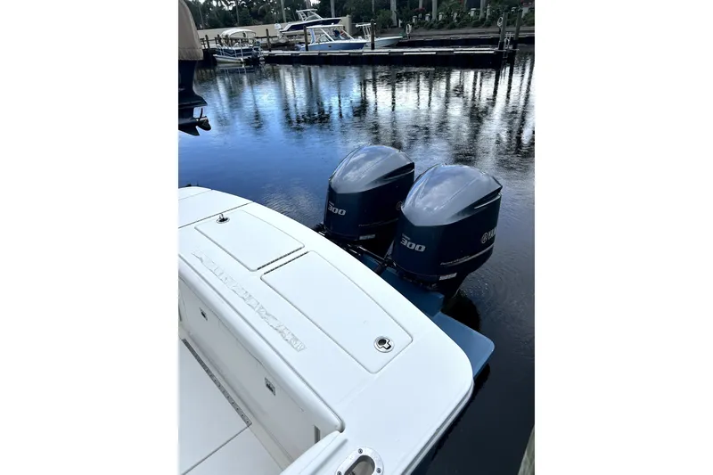 Slide: The Image of 2016 Regulator 28 Forward Seating boat with twin Yamaha 300 engines docked by the water. - 10