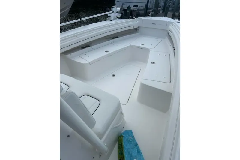 Slide: The Image of 2016 Regulator 28 Forward Seating boat interior with white cushioned seats and storage compartments. - 11