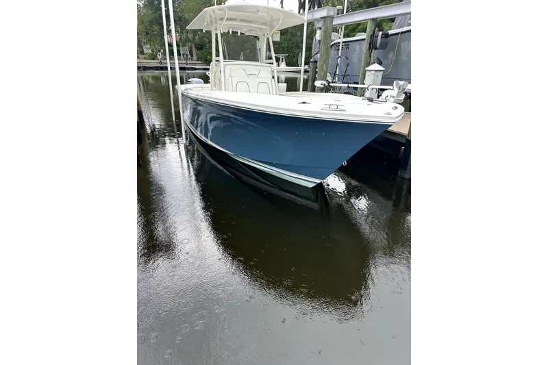 Slide: The Image of 2016 Regulator 28 Forward Seating boat docked on calm water. - 2