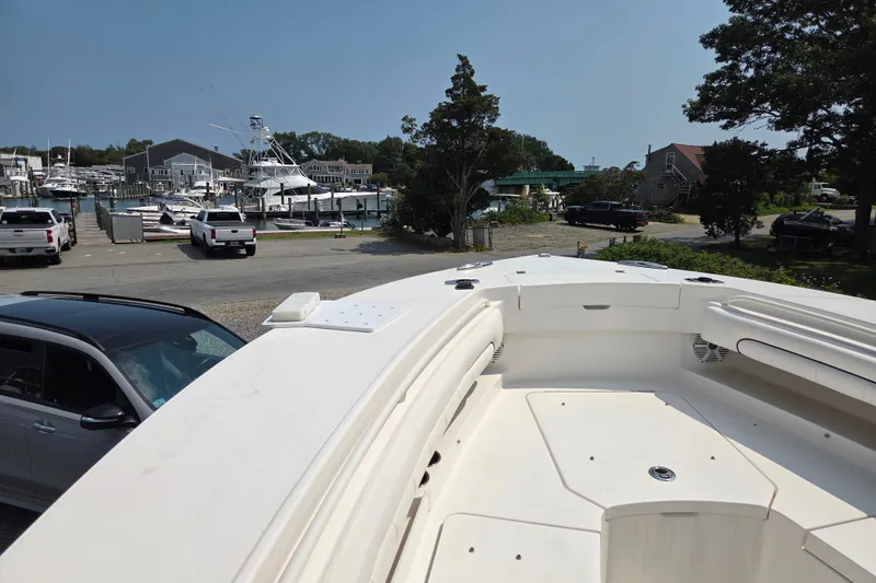 Slide: The Image of 2016 Regulator 28 Forward Seating boat at marina with parked vehicles and waterfront view. - 9