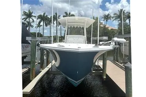 Slide: The Image of 2016 Regulator 28 Forward Seating boat docked, surrounded by palm trees and clear skies. - 3