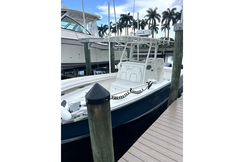 Slide: The Image of 2016 Regulator 28 Forward Seating boat docked, featuring sleek design and modern equipment. - 4