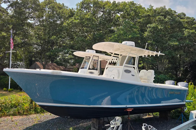The Image of 2016 Regulator 28 Forward Seating boat displayed outdoors with lush greenery background. - 0