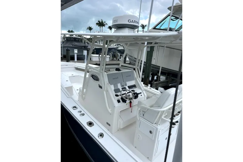 Slide: The Image of 2016 Regulator 28 Forward Seating boat with Garmin navigation, docked under cloudy skies. - 6