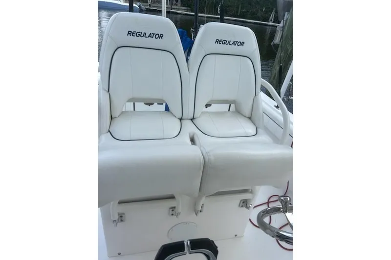 Slide: The Image of 2016 Regulator 28 Forward Seating boat with white cushioned seats. - 9