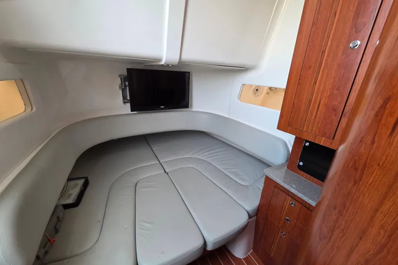 Slide: The Image of 2016 Regulator 41 cabin interior with TV, gray seating, and wooden cabinetry. - 11